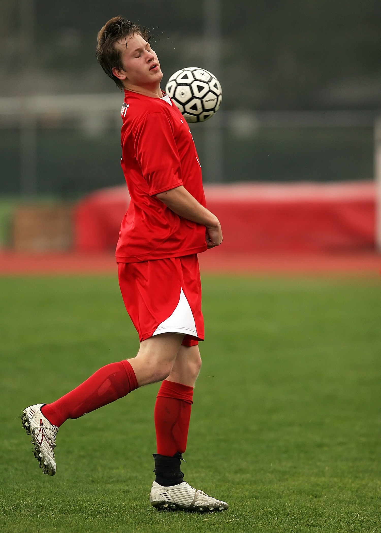 Soccer Player In Red Uniform With A Ball On The Soccer Field Free Image