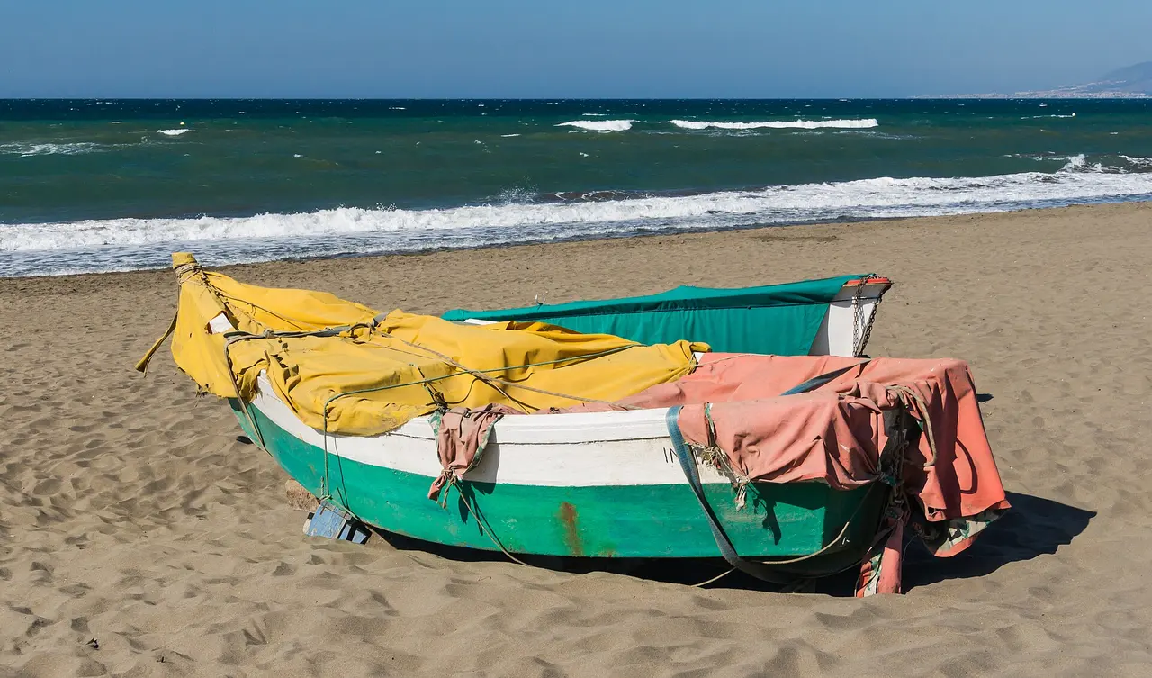 Painted wooden fishing boats pulled up on a sandy beach