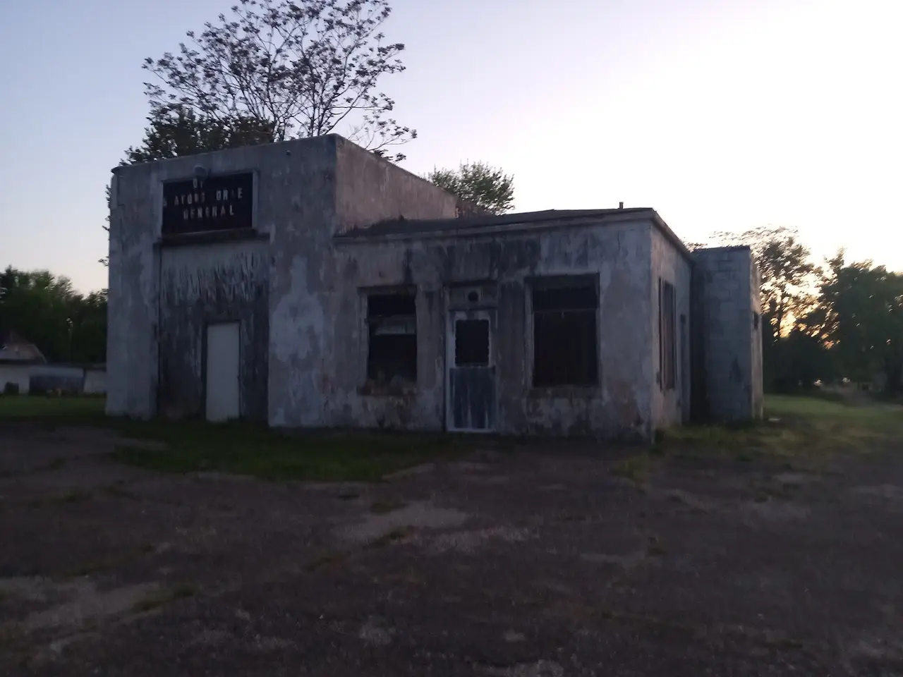 A closed and weathered gas station with an empty forecourt