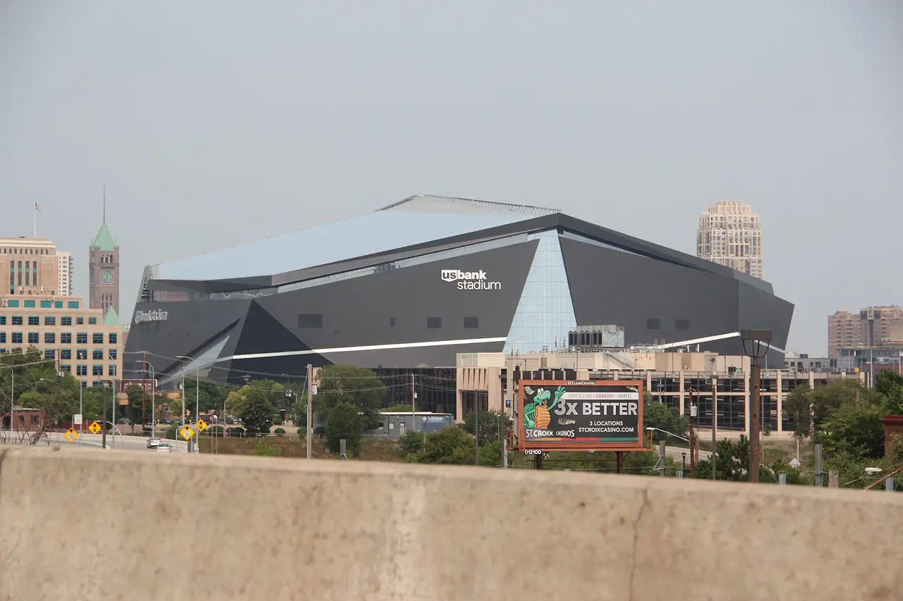 The angular roof of U.S. Bank Stadium beside city buildings in Minneapolis