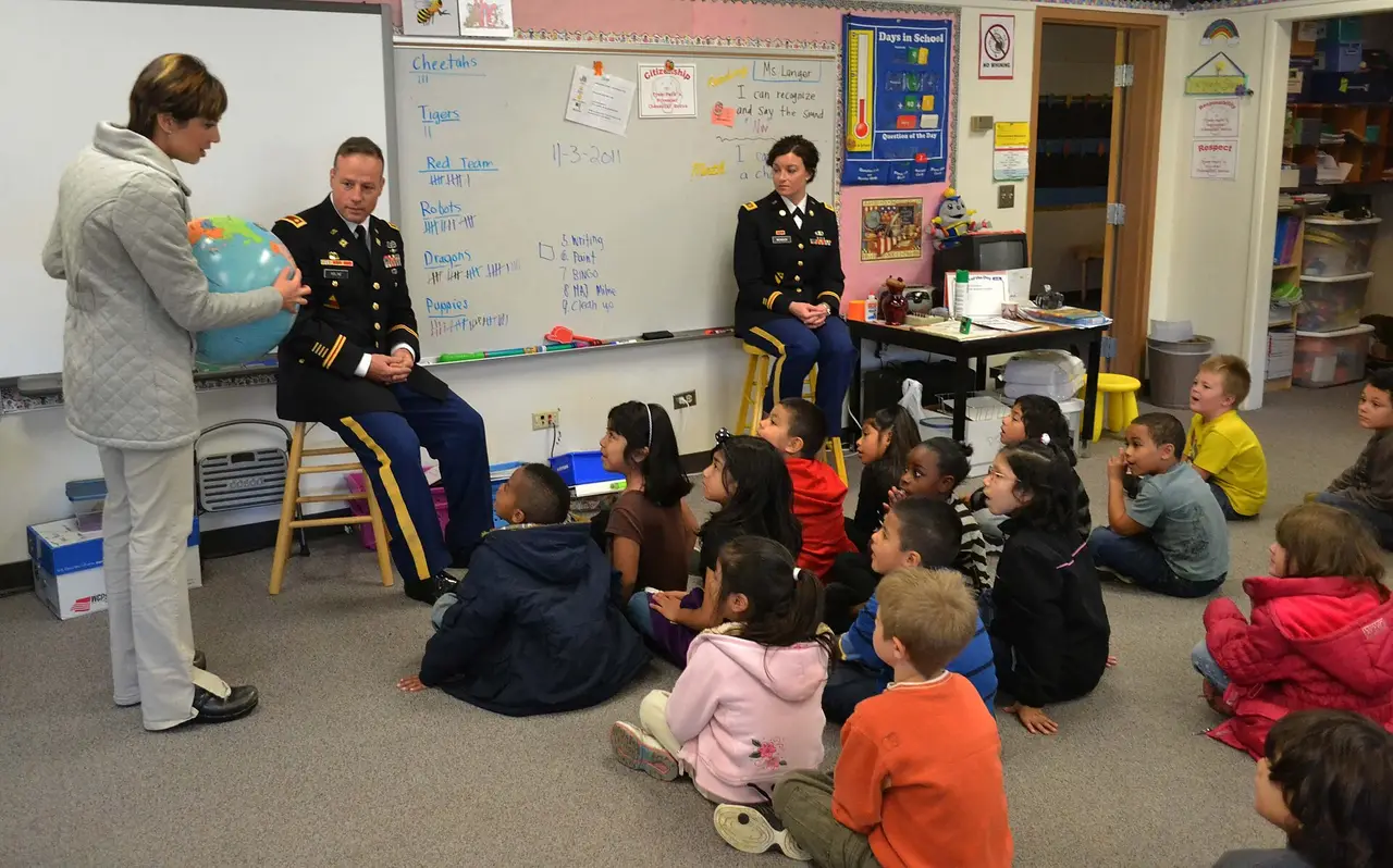 Teacher and two officers speaking to children sitting on a classroom floor