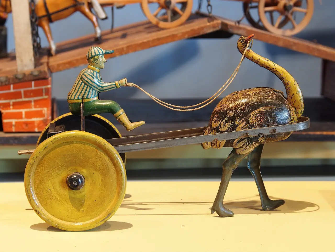 Old tin toy with a rider on a cart behind an ostrich