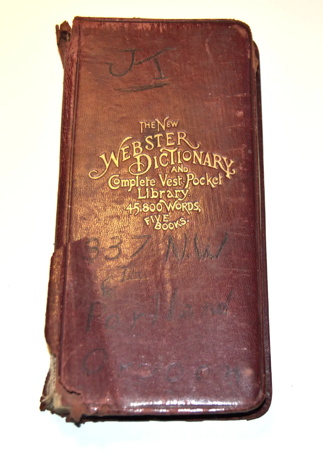 A small leather-bound pocket dictionary with a worn cover