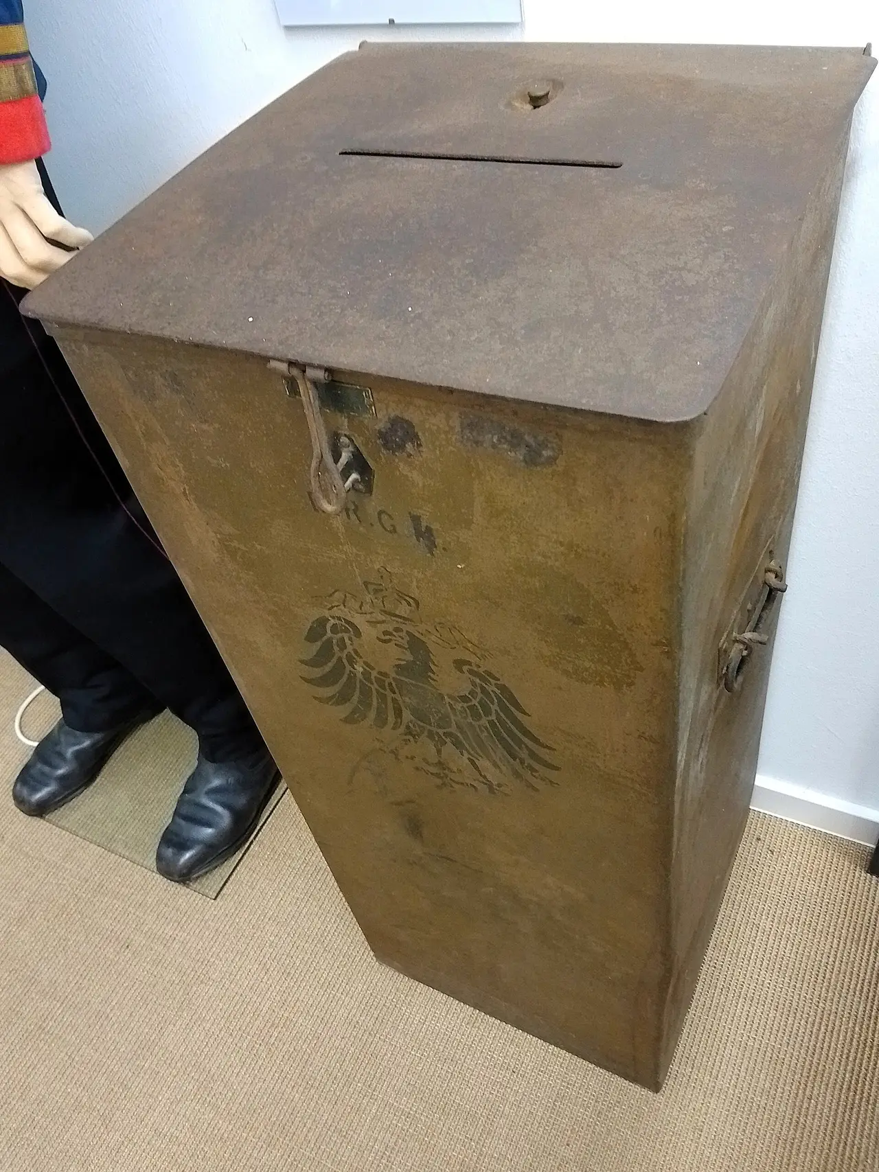 Tall brown box with a slot in the lid and a carved eagle on the front