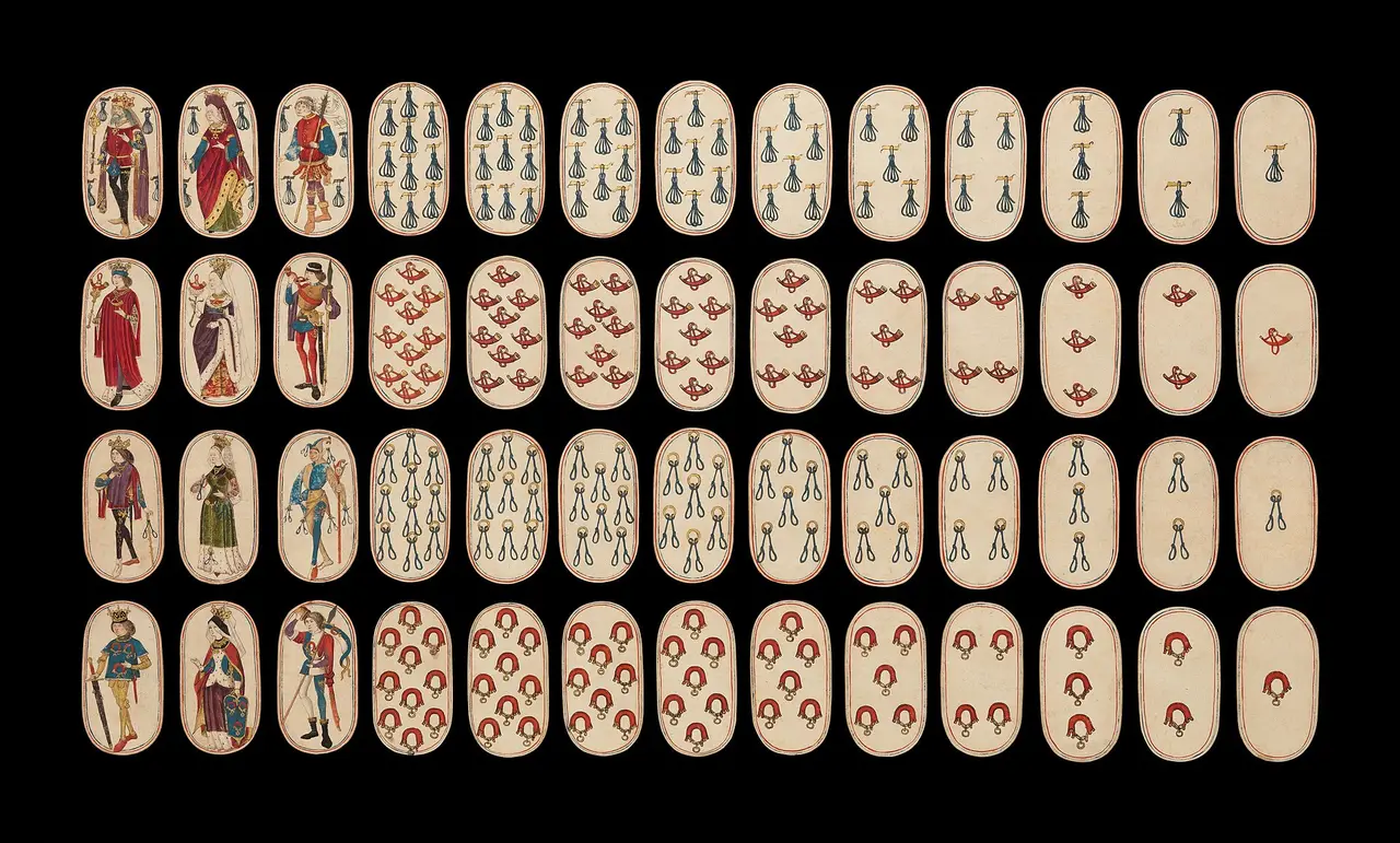 Rows of old oval playing cards laid out on a black background