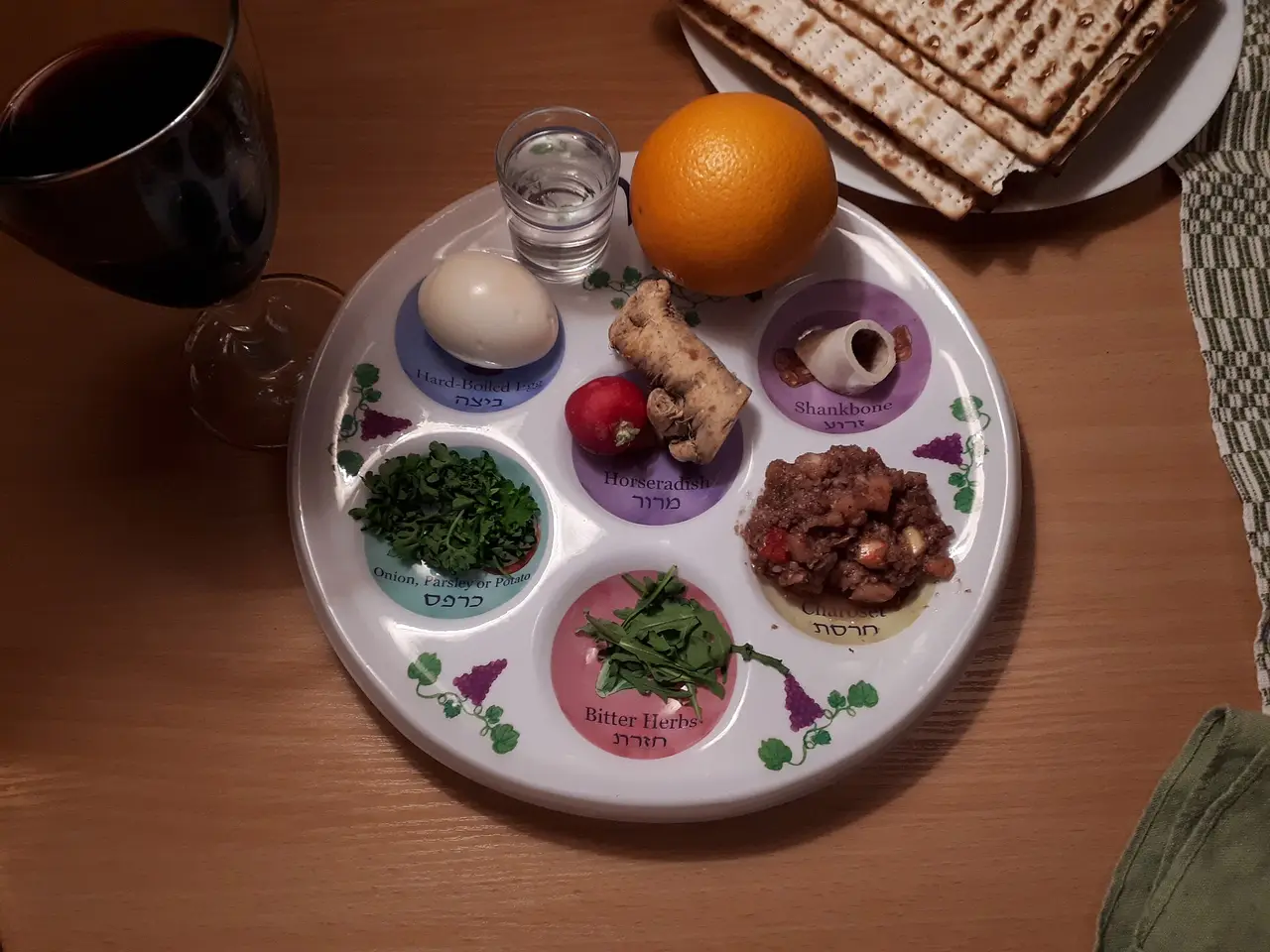 A Seder plate with symbolic foods, wine and matzot on a table