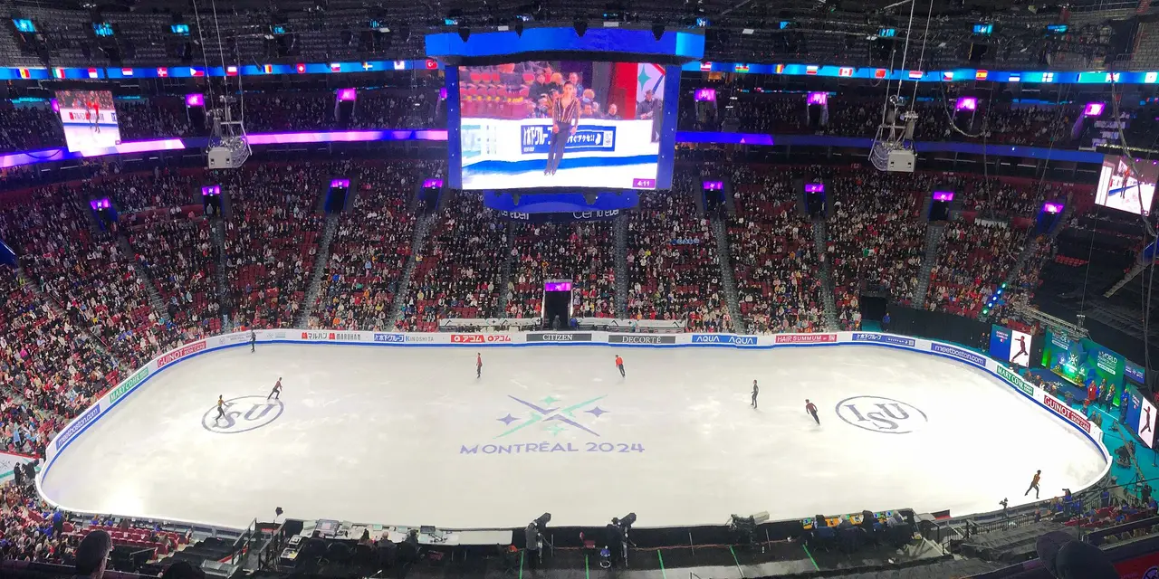 A packed ice arena in Montreal seen from the stands, with skaters on the rink