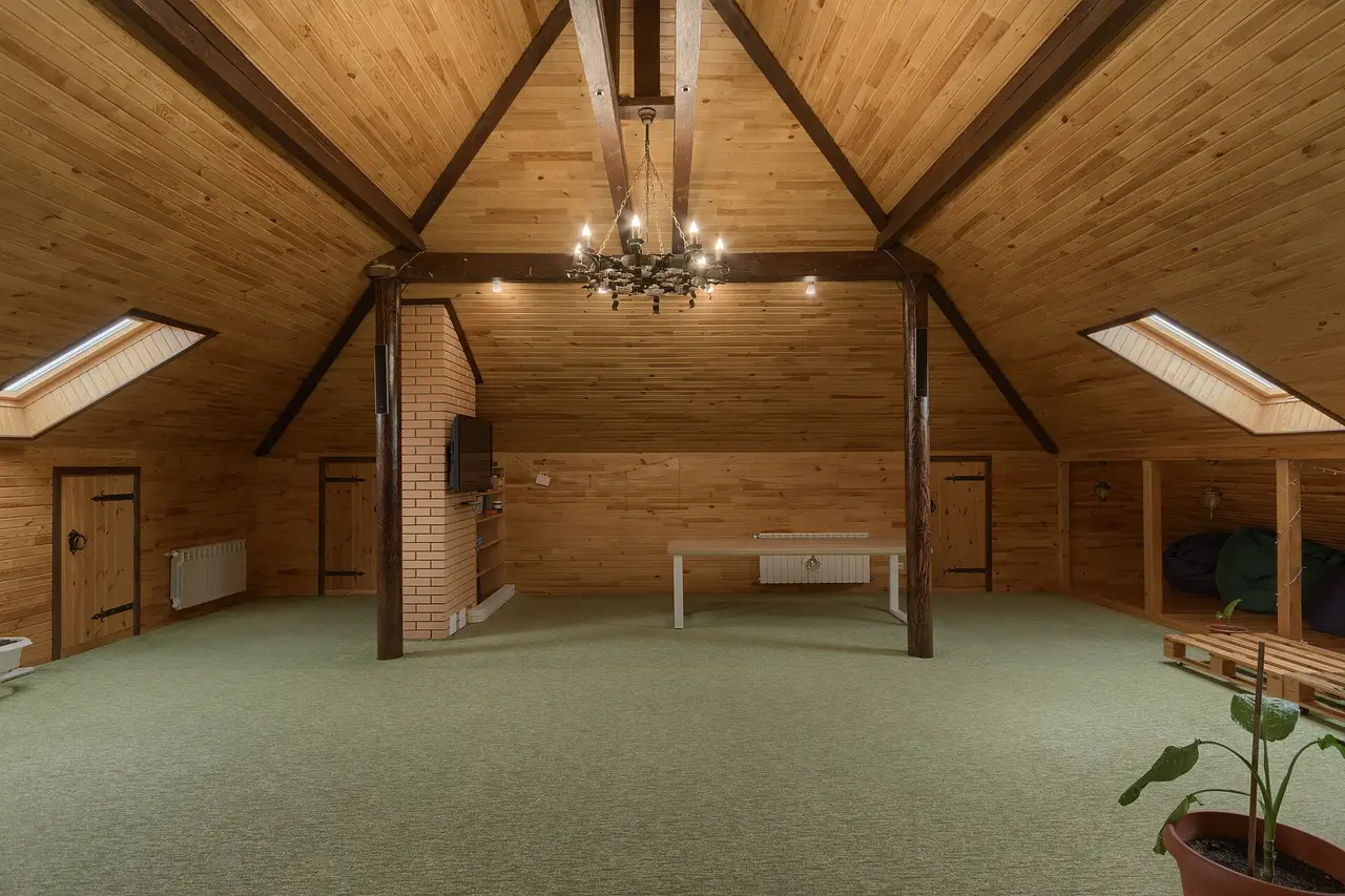 Pine-panelled attic room with skylights and a chandelier