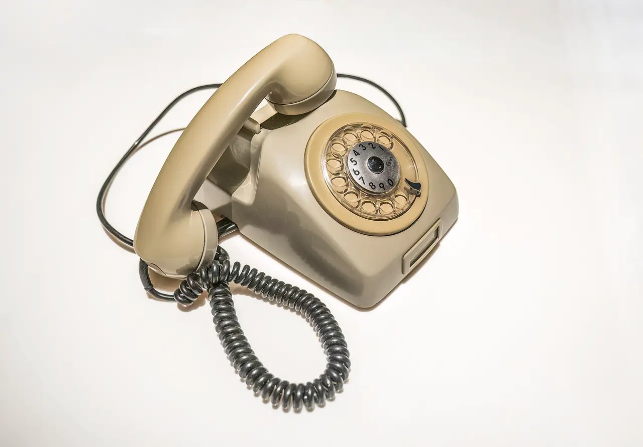 Grey rotary dial telephone with a coiled cord