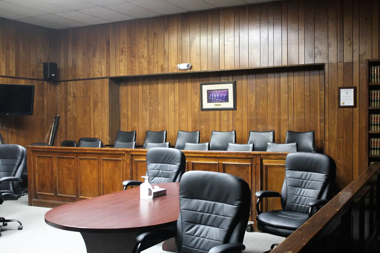 Rows of black chairs in a wood-panelled jury box inside a courtroom