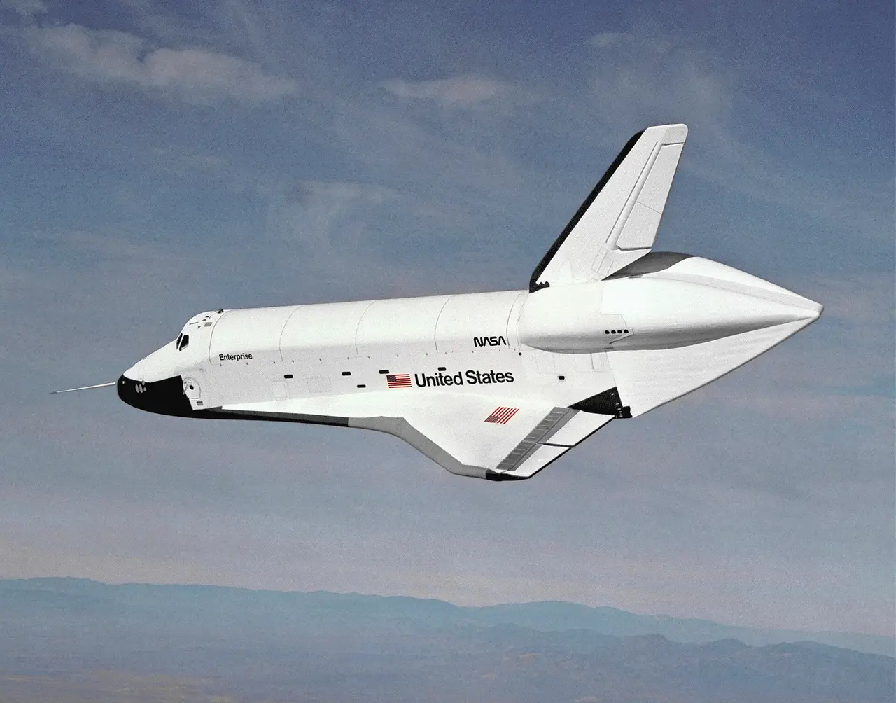 A white space shuttle gliding in the air above a desert