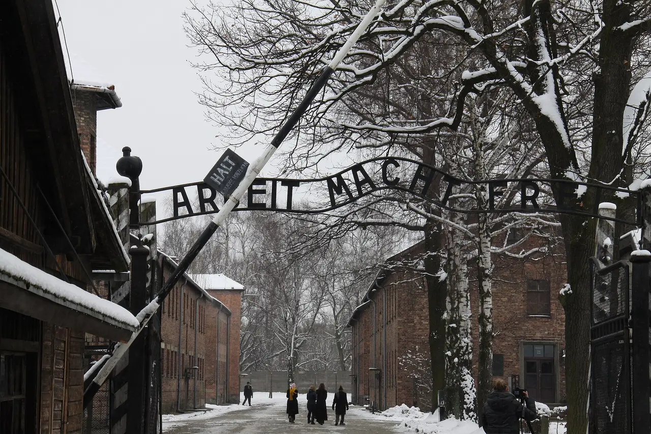 The camp gate with its iron lettering, brick huts and snow
