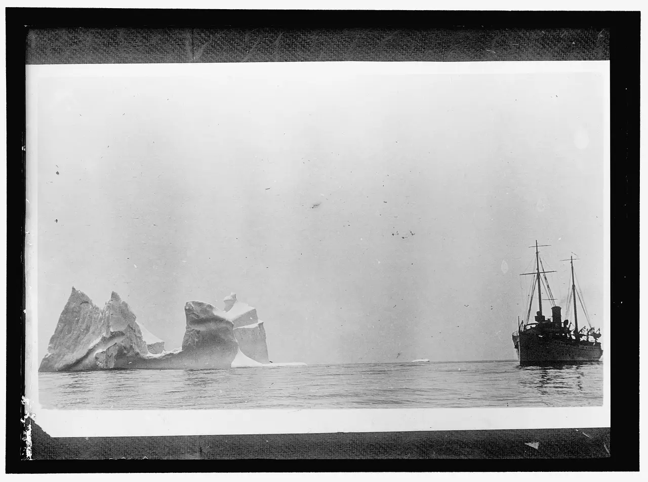 A steamship beside a large iceberg on a calm sea