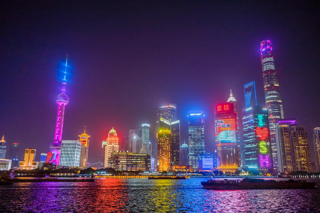 Lit skyscrapers of Shanghai reflected in the river at night