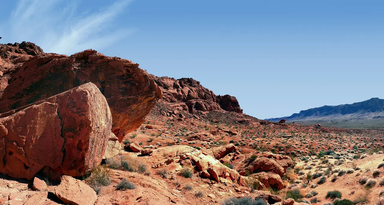 Red boulders and desert scrub under a blue sky