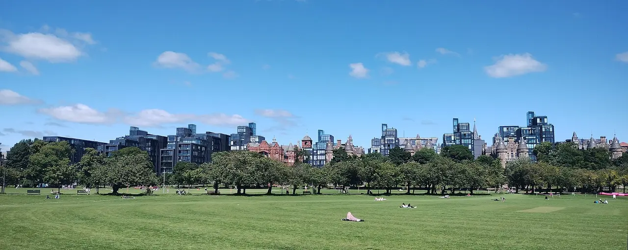 Buildings of central Edinburgh behind a park with trees