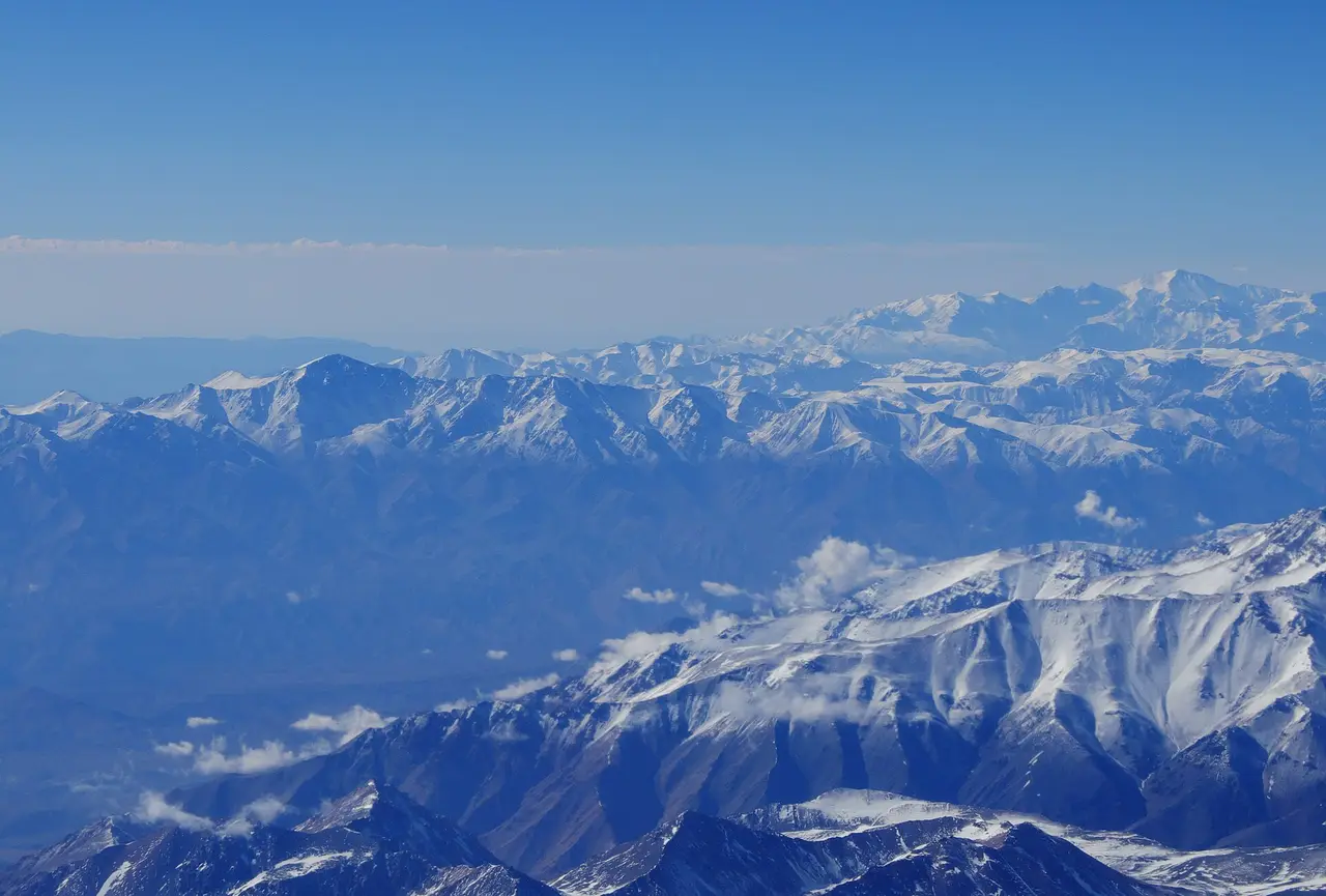 Snowy mountain ridges stretching under a blue sky