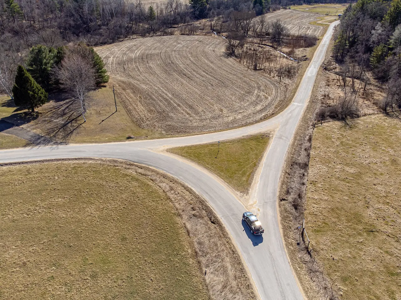 Aerial view of a road dividing into two branches beside fields