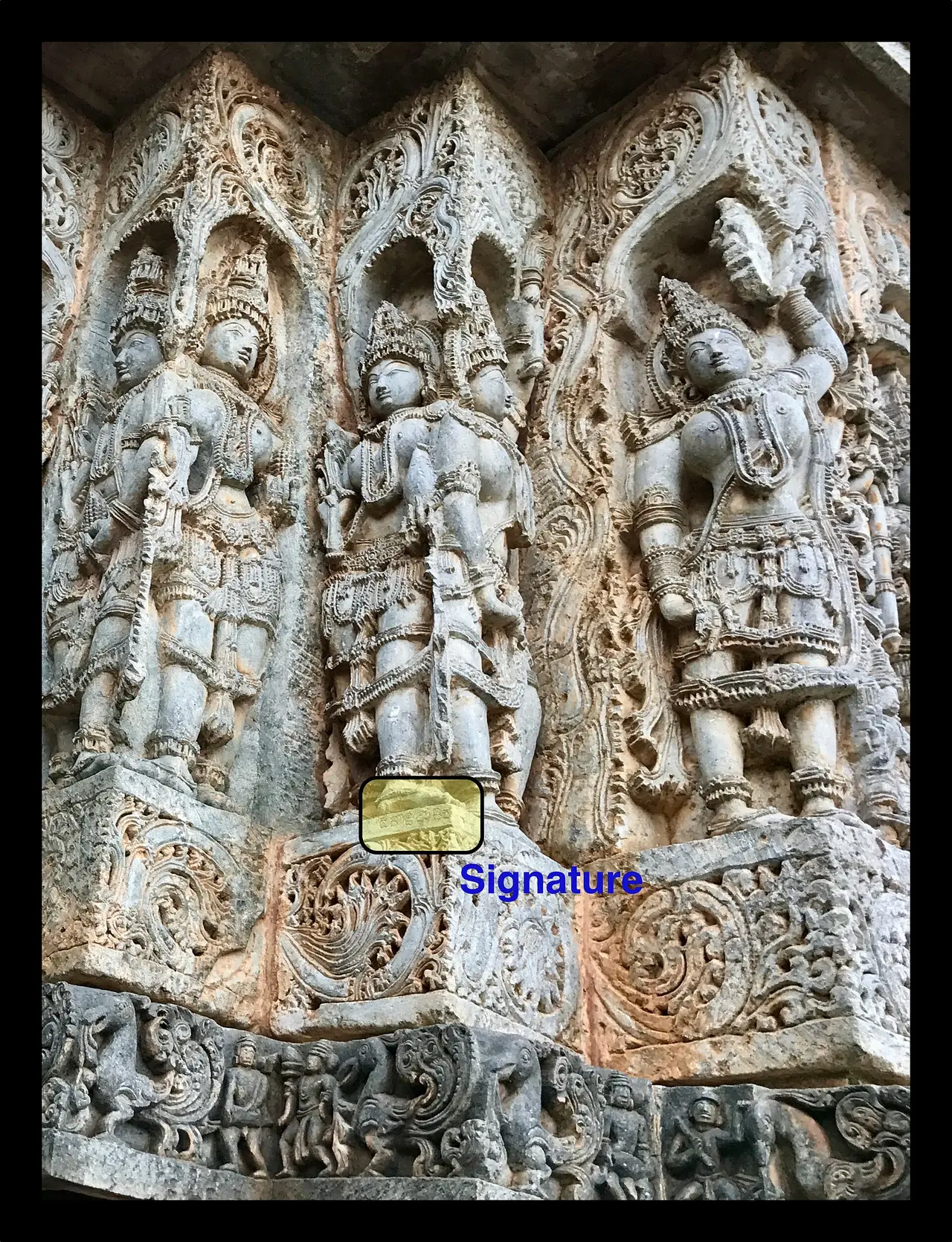 Dense stone carvings of figures on the wall of an Indian temple