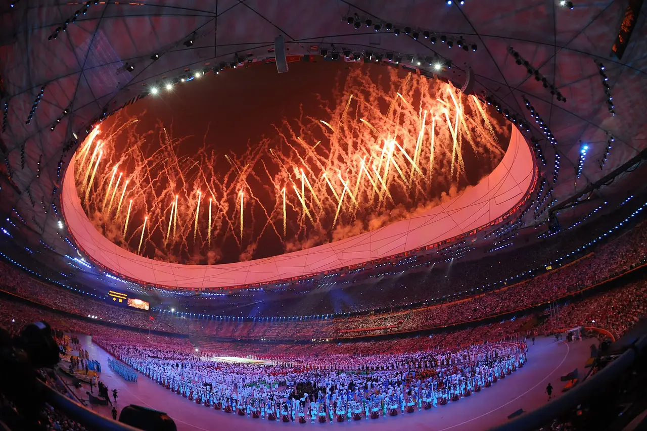 Orange fireworks above a packed Olympic stadium during the opening ceremony
