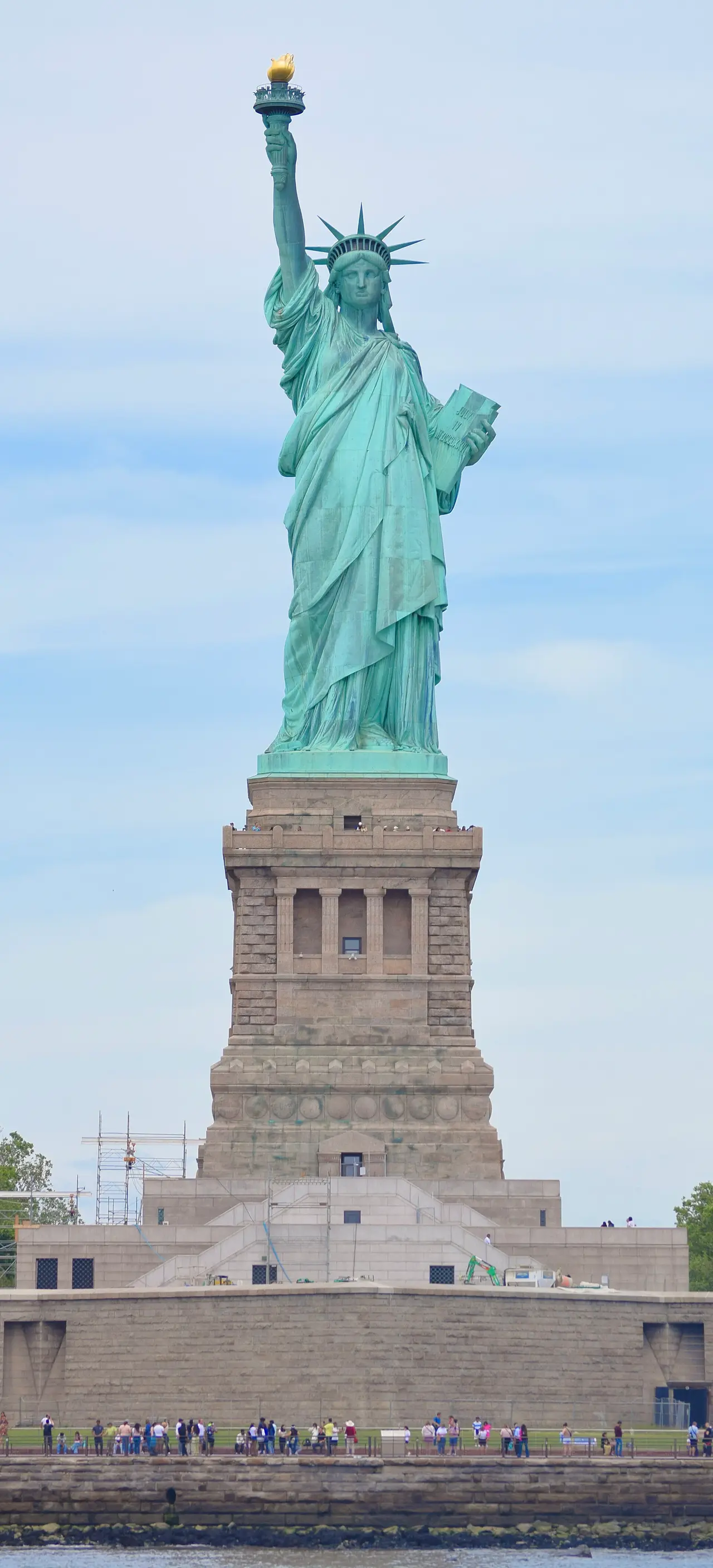 The green Statue of Liberty standing on its stone pedestal