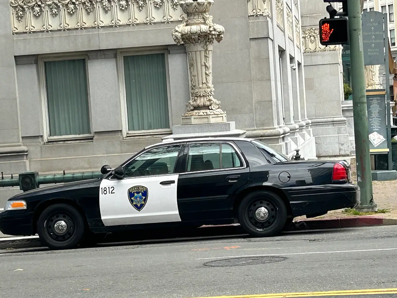 A black and white police car parked beside a stone building