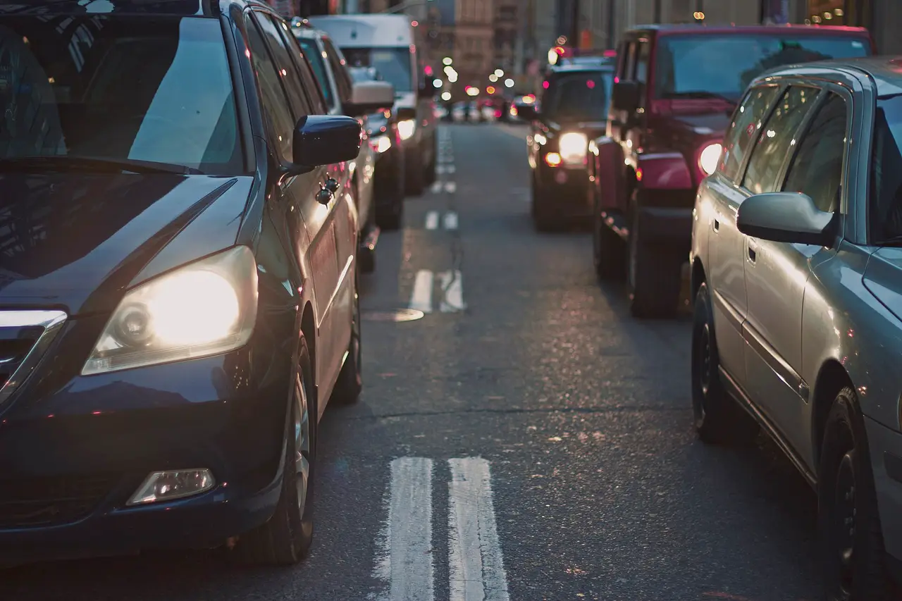 Cars in a traffic queue with their headlights lit
