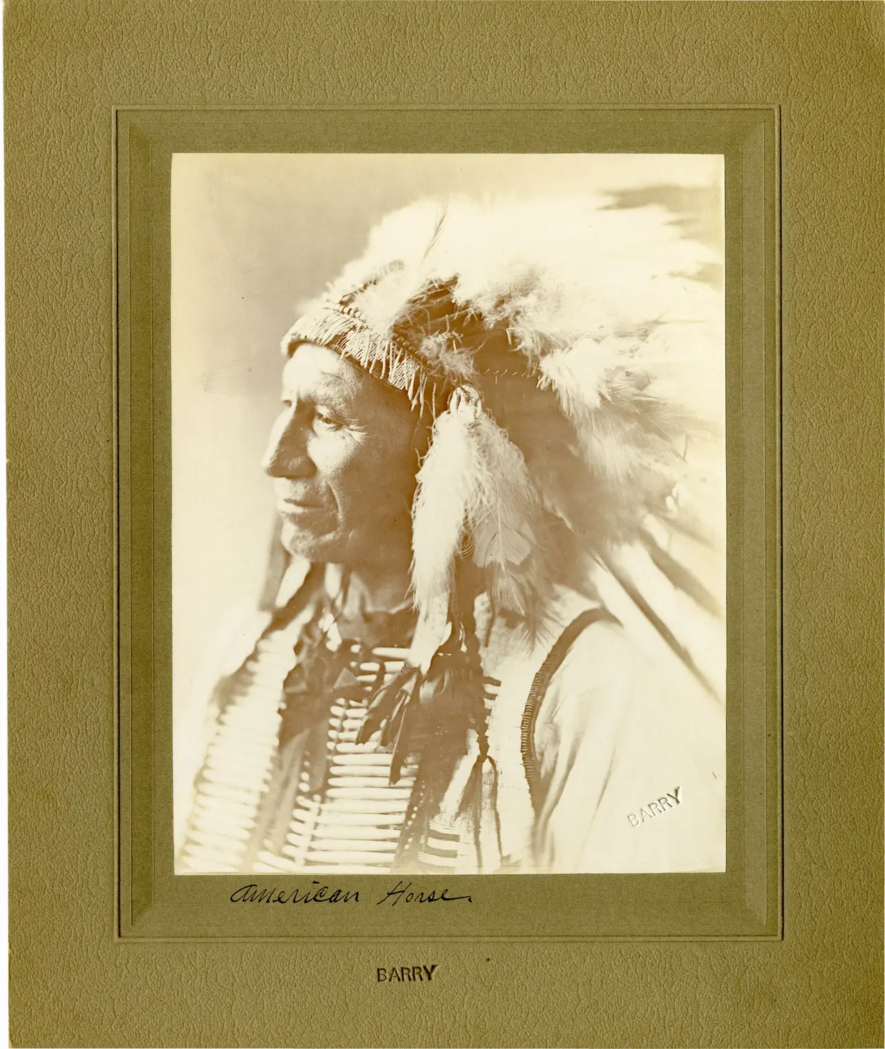 Sepia portrait of a man in a feathered headdress