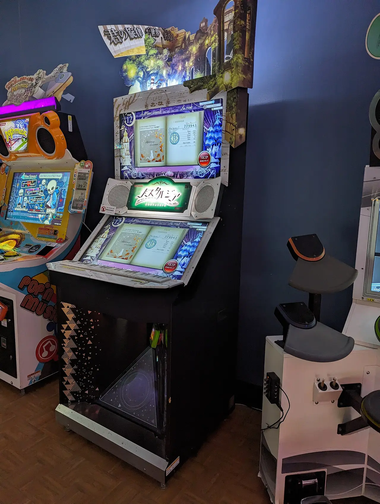 Upright arcade cabinet with a lit screen beside other game machines