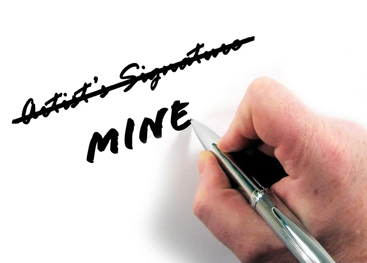 A hand with a pen striking out a signature and writing the word mine