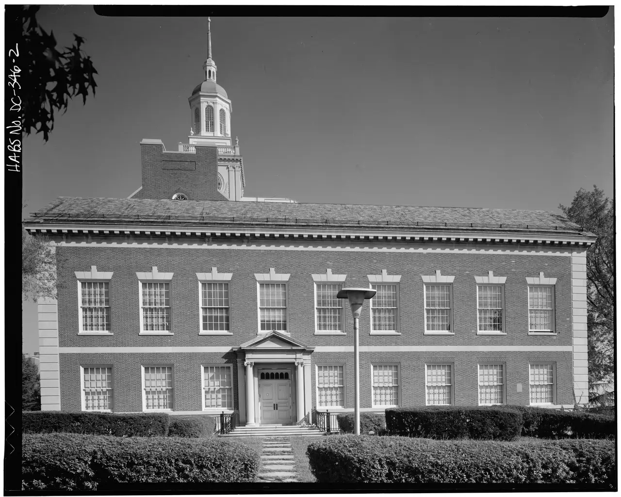 A brick university library building with a central entrance and tower