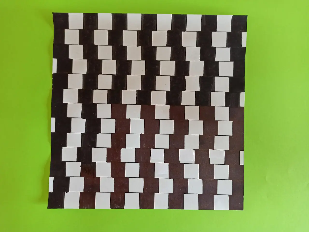 Rows of white and brown rectangles on a green sheet that look tilted
