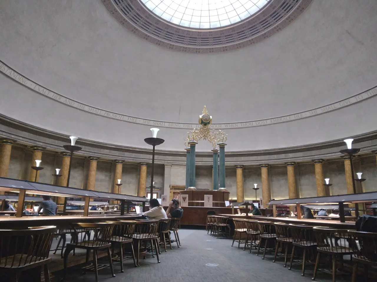 Readers at long tables in a domed circular library reading room