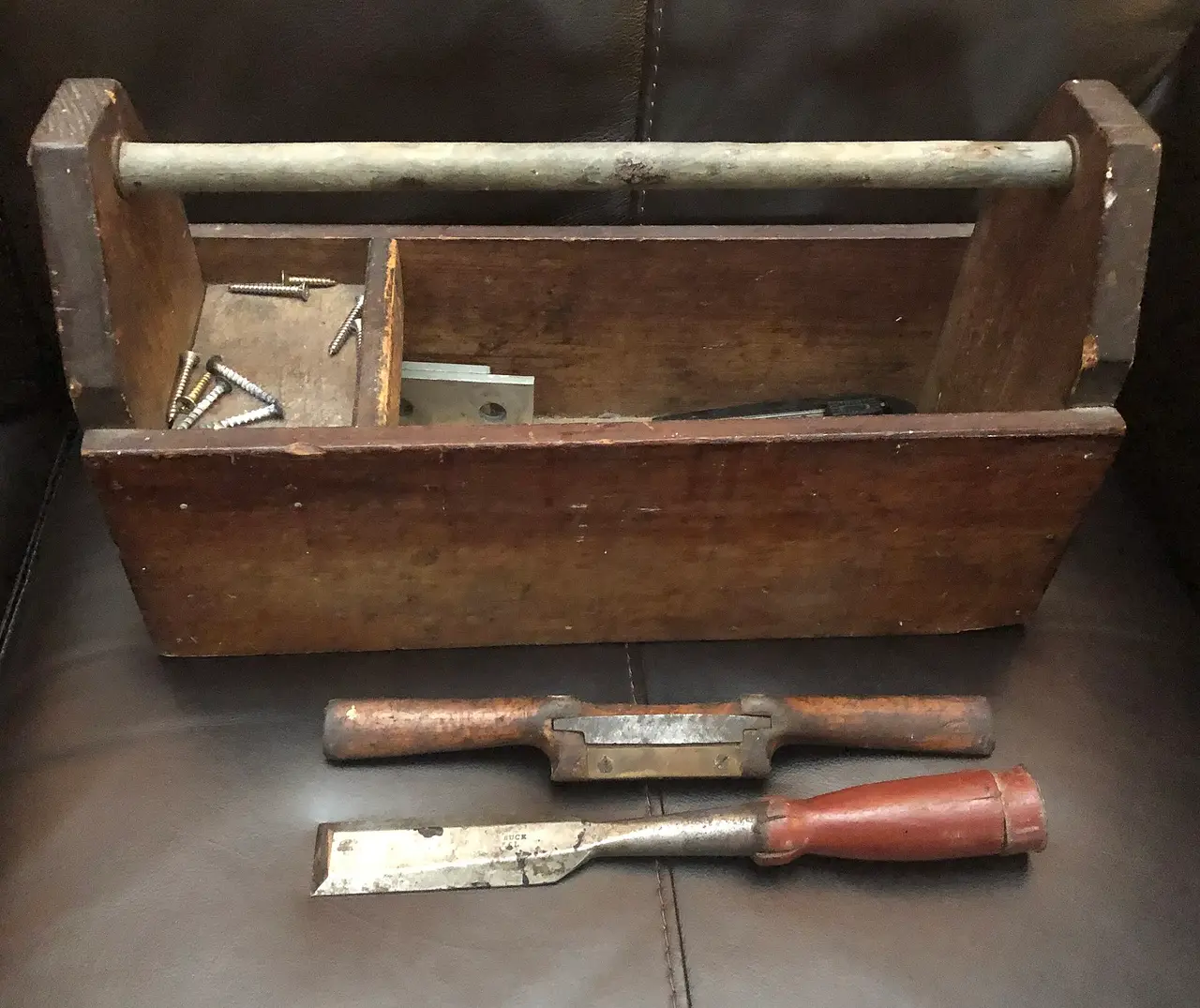 Old wooden toolbox with a chisel and plane in front