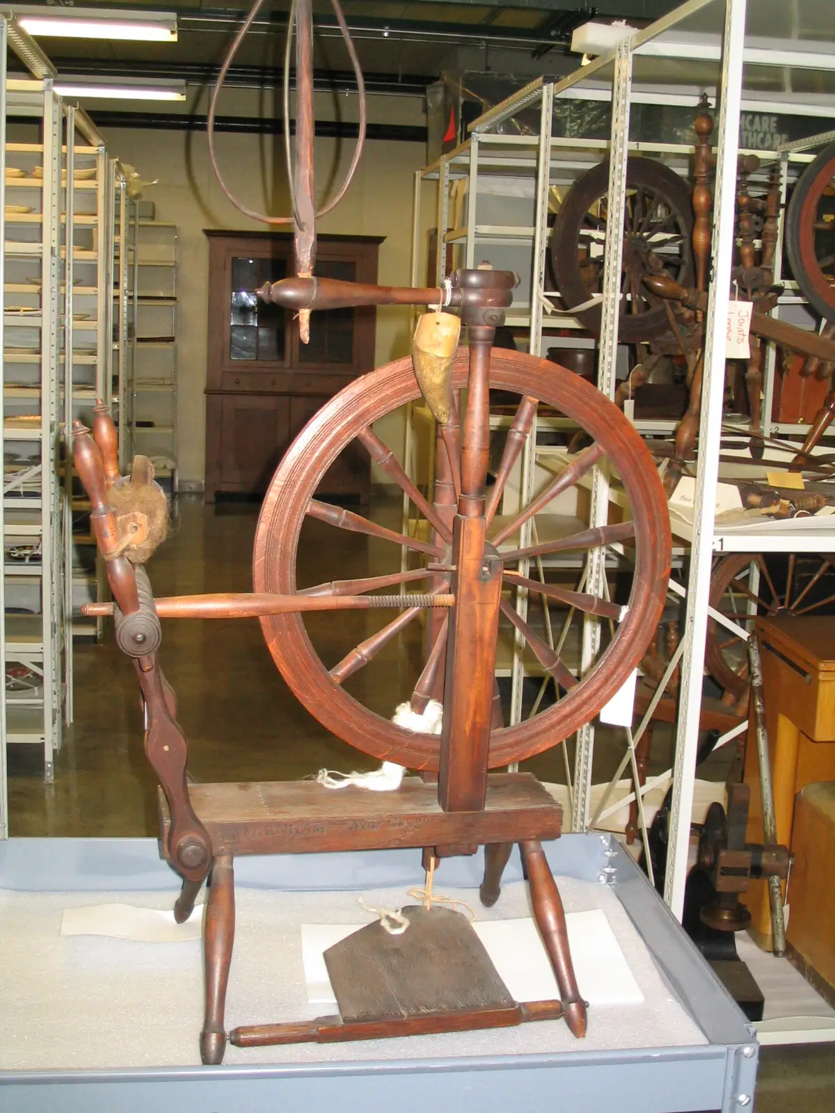Wooden flax spinning wheel with a large wheel on display