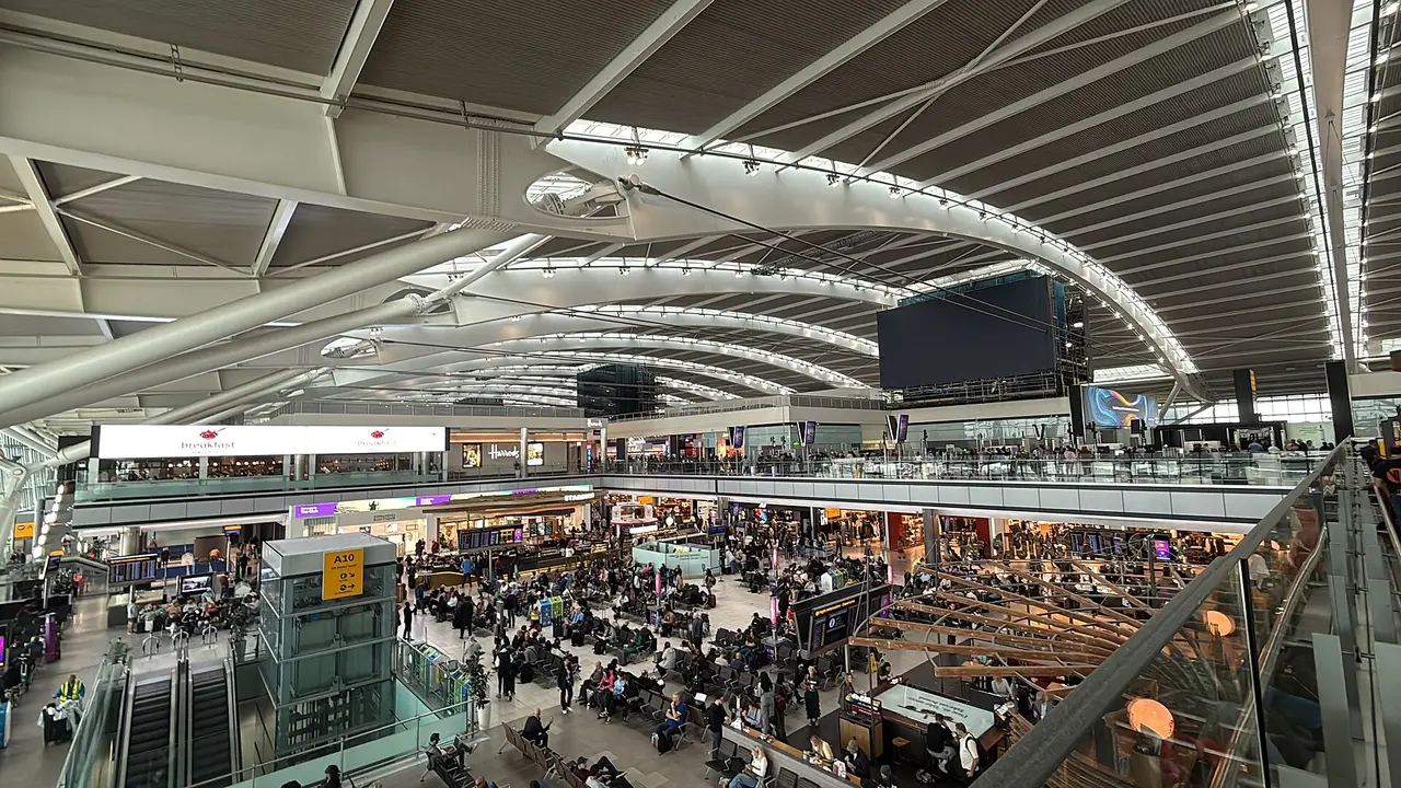 Passengers in the large glass-roofed hall of Heathrow Terminal 5