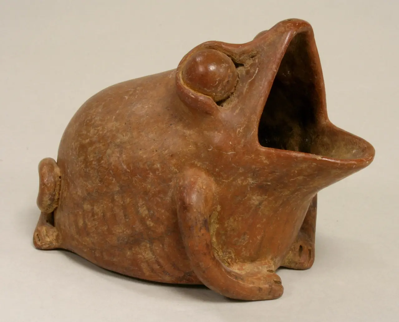 Brown ceramic vessel in the shape of a frog with its mouth open