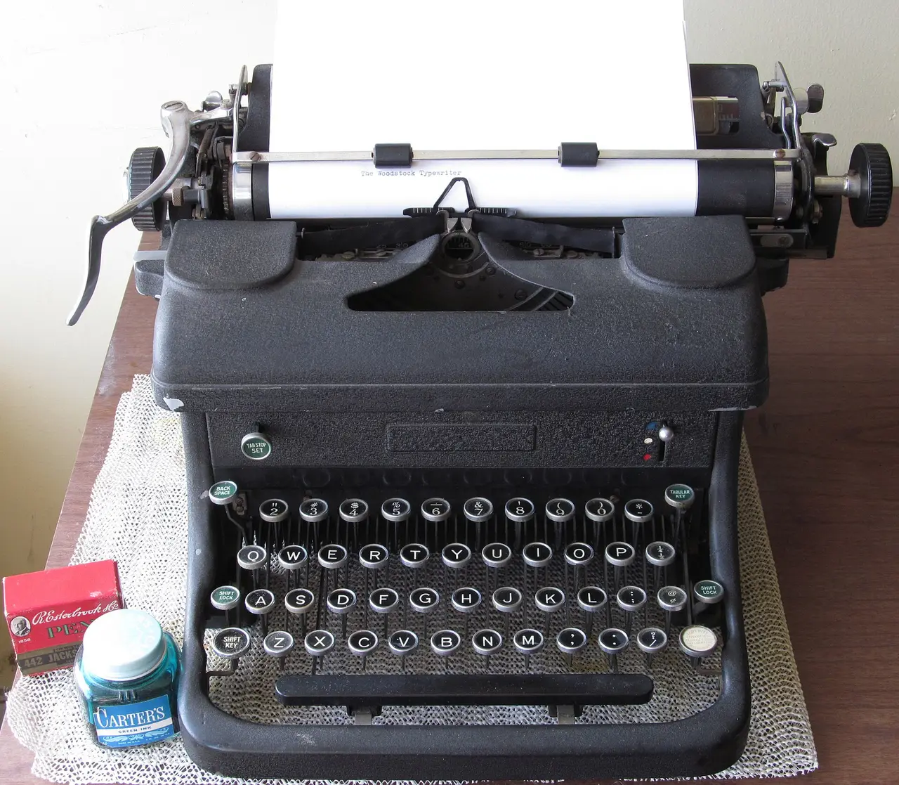A black 1940s typewriter with a sheet of paper in it