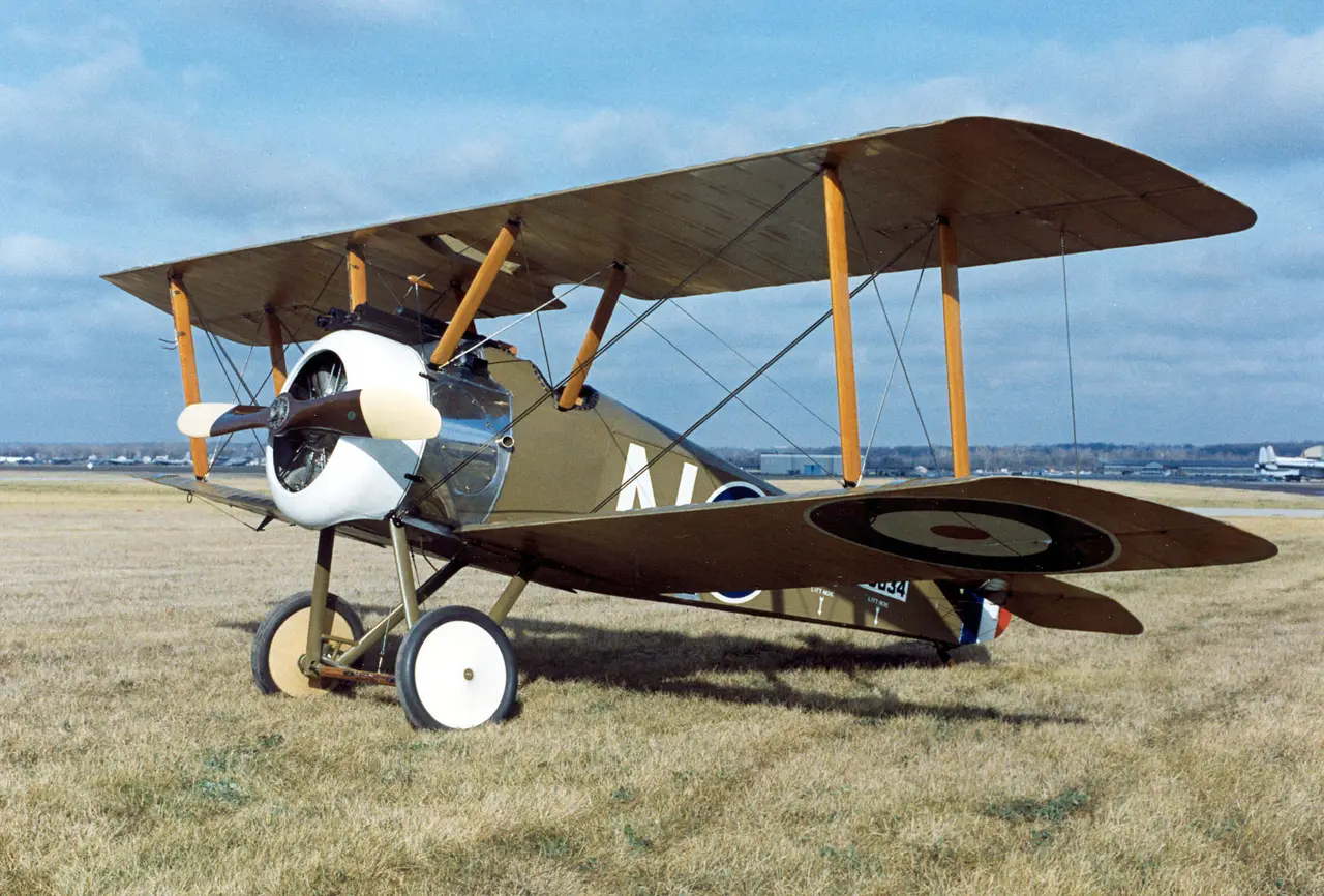 A Sopwith Camel biplane with RAF roundels parked on grass