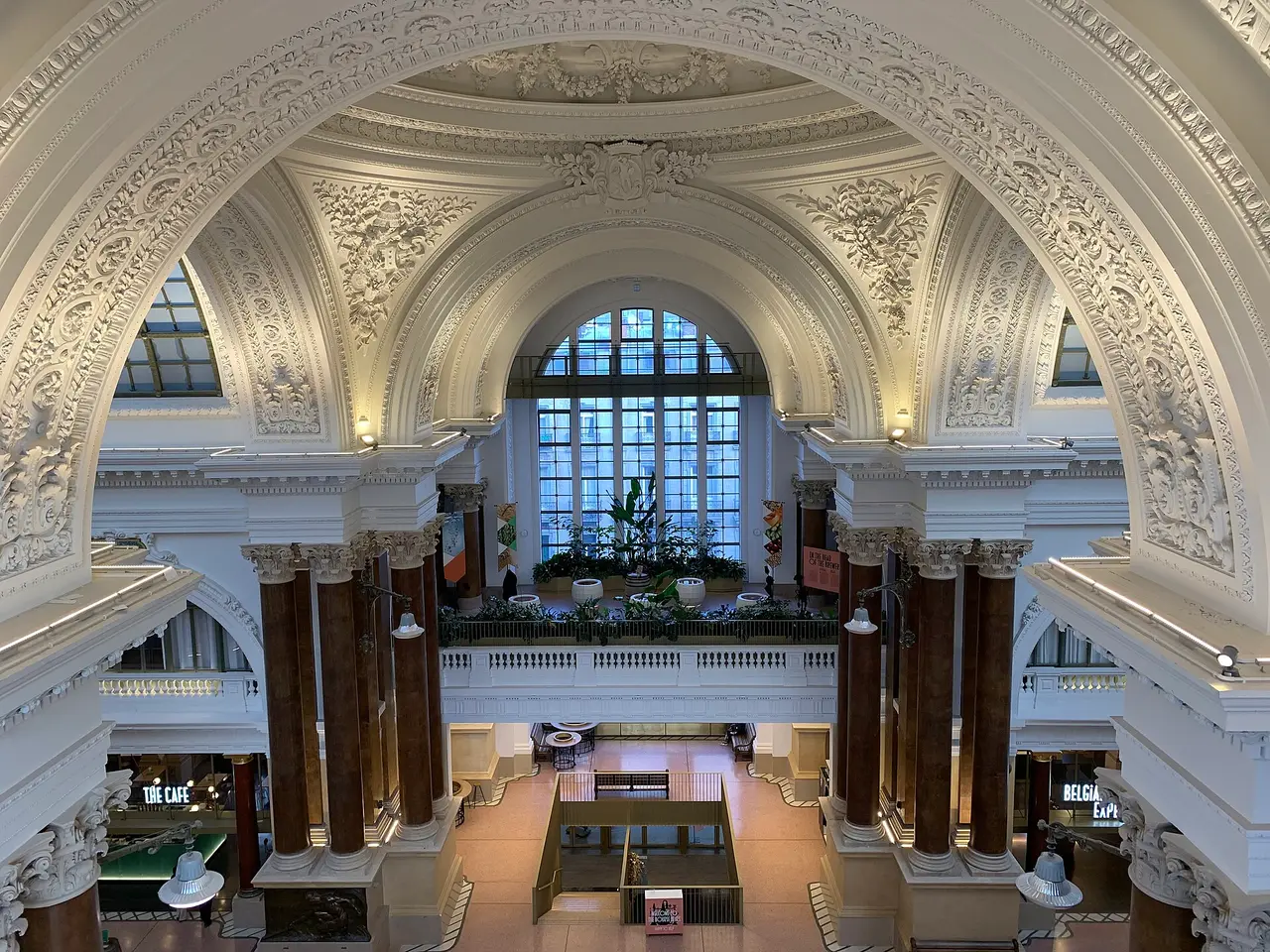 An ornate white domed hall with arched windows and columns inside a stock exchange