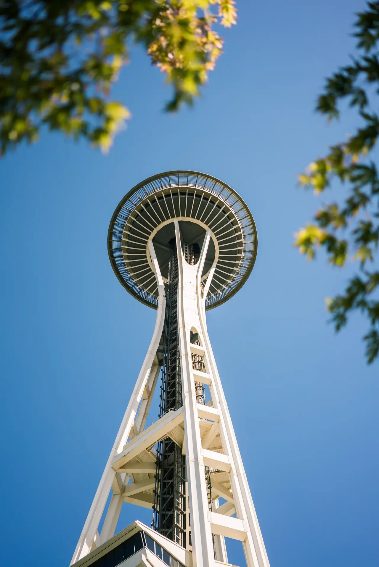 The Space Needle tower seen from below against a blue sky
