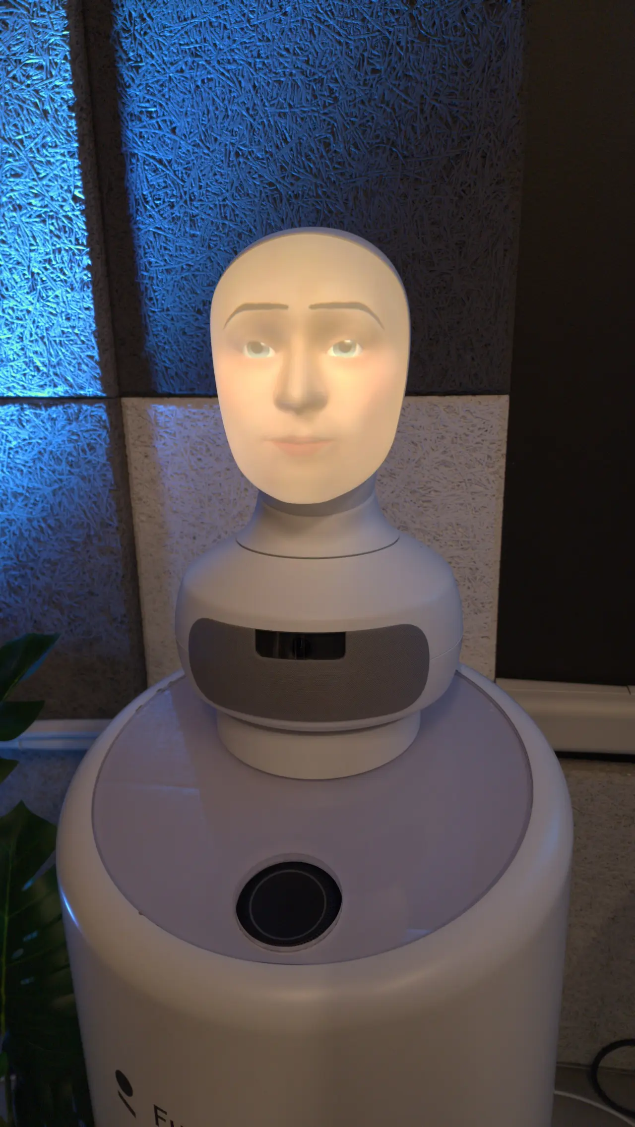 A robot with a pale human face on a white base
