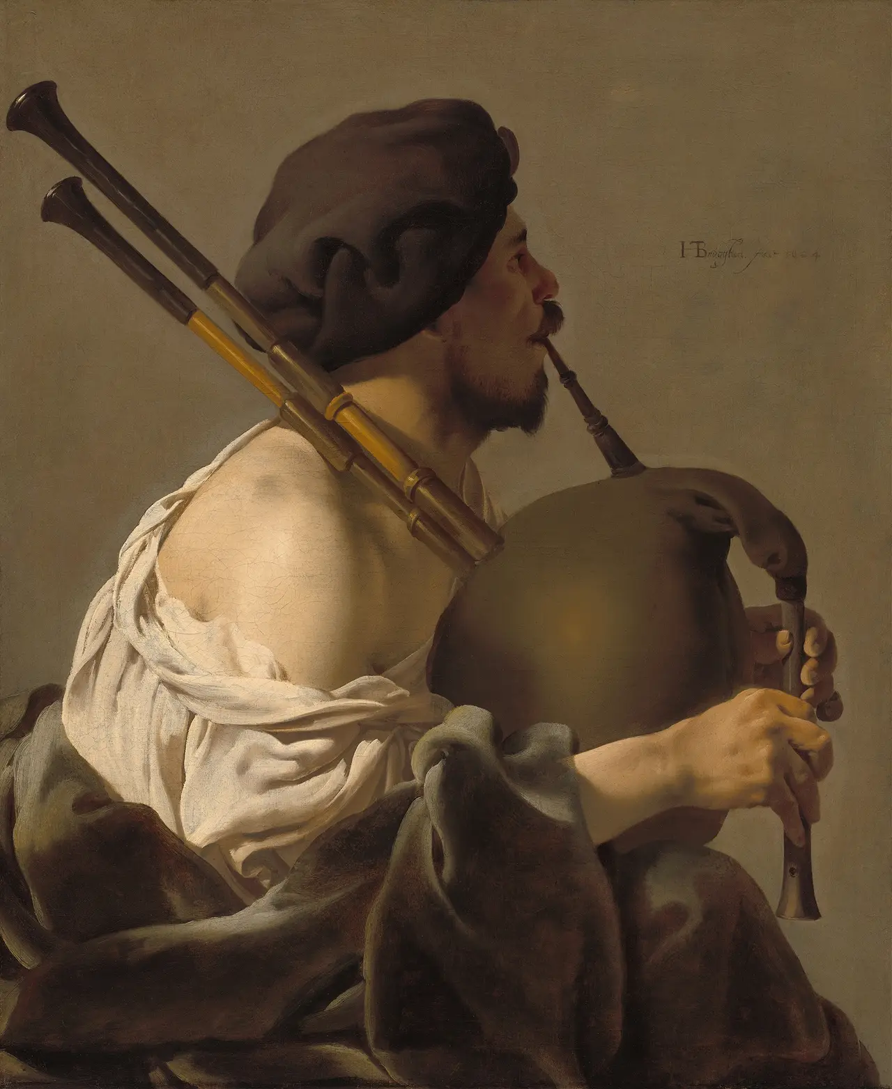 A painted bagpipe player in a dark cap, seen from the side