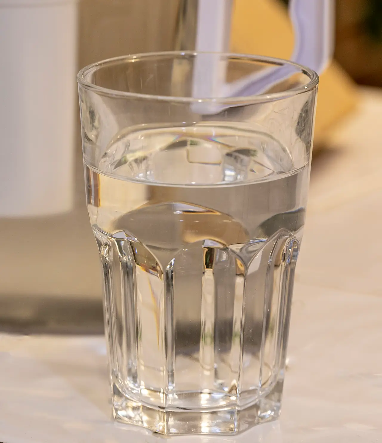 A clear glass tumbler of water on a table