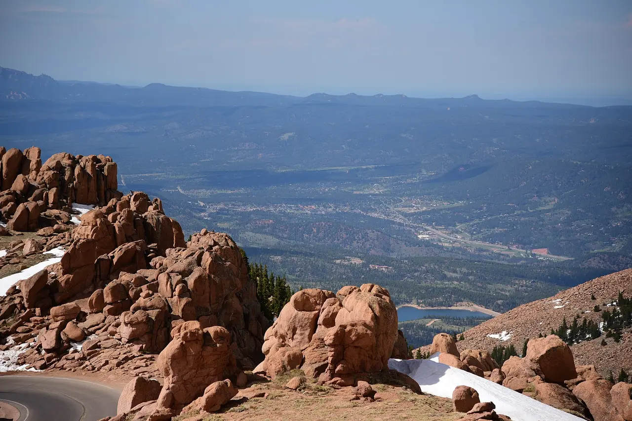 Red rock outcrops above a wide valley seen from Pikes Peak