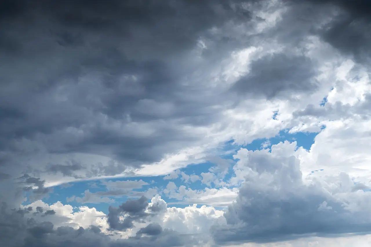 Heavy grey and white storm clouds across a blue sky