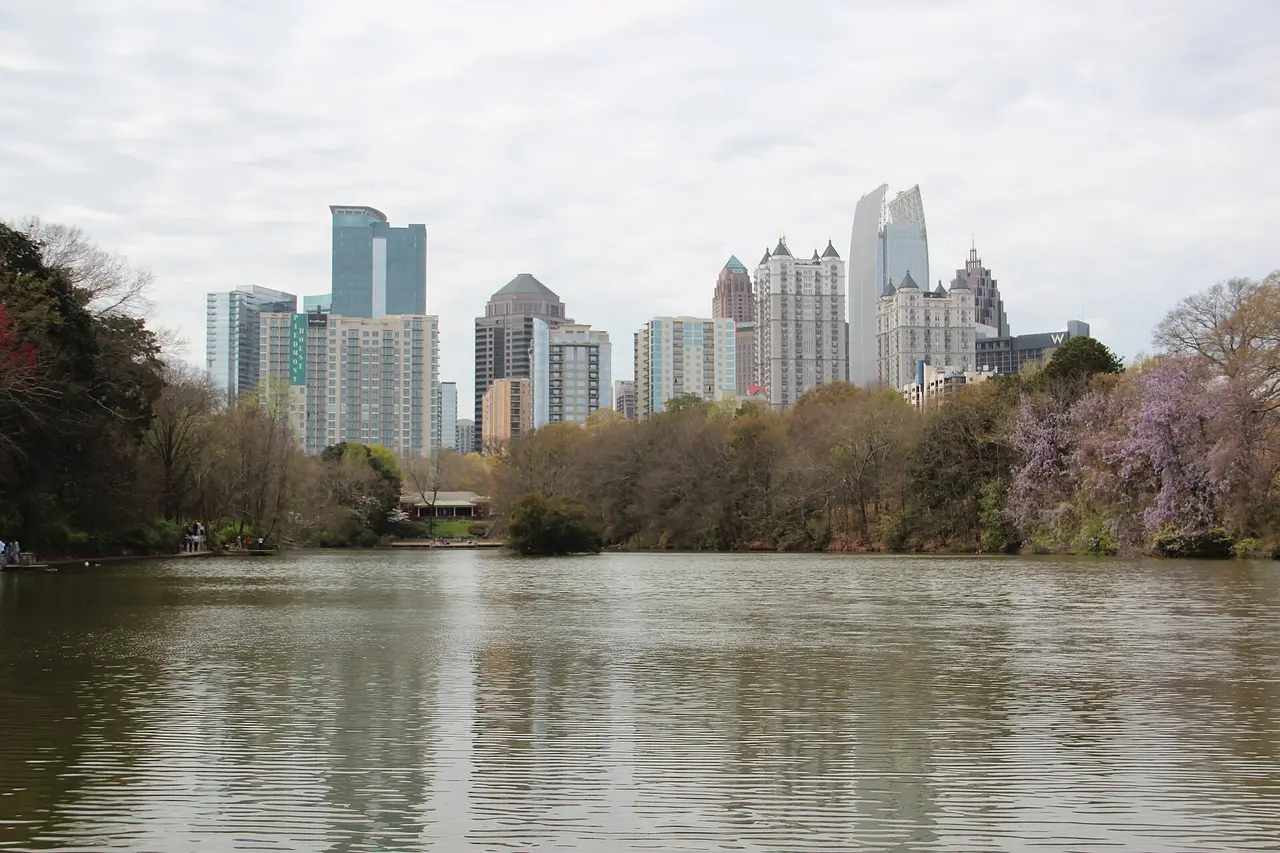 Midtown Atlanta towers rising above trees across a park lake