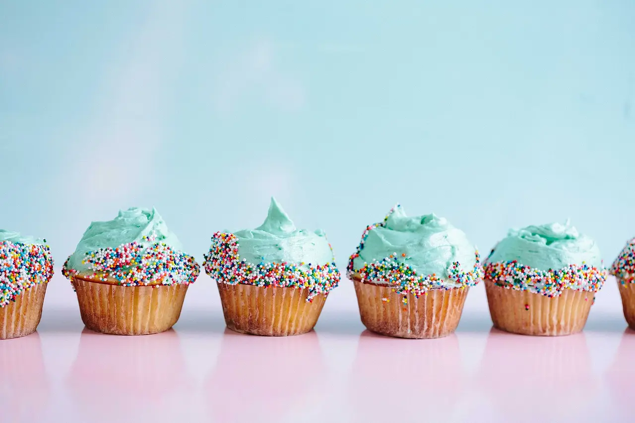 Row of cupcakes with blue icing and sprinkles