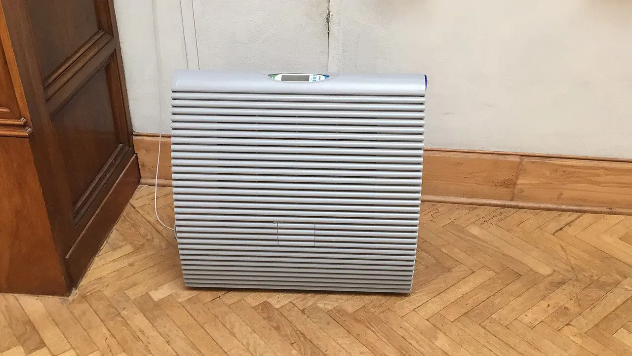 Grey floor-standing humidifier on a herringbone parquet floor