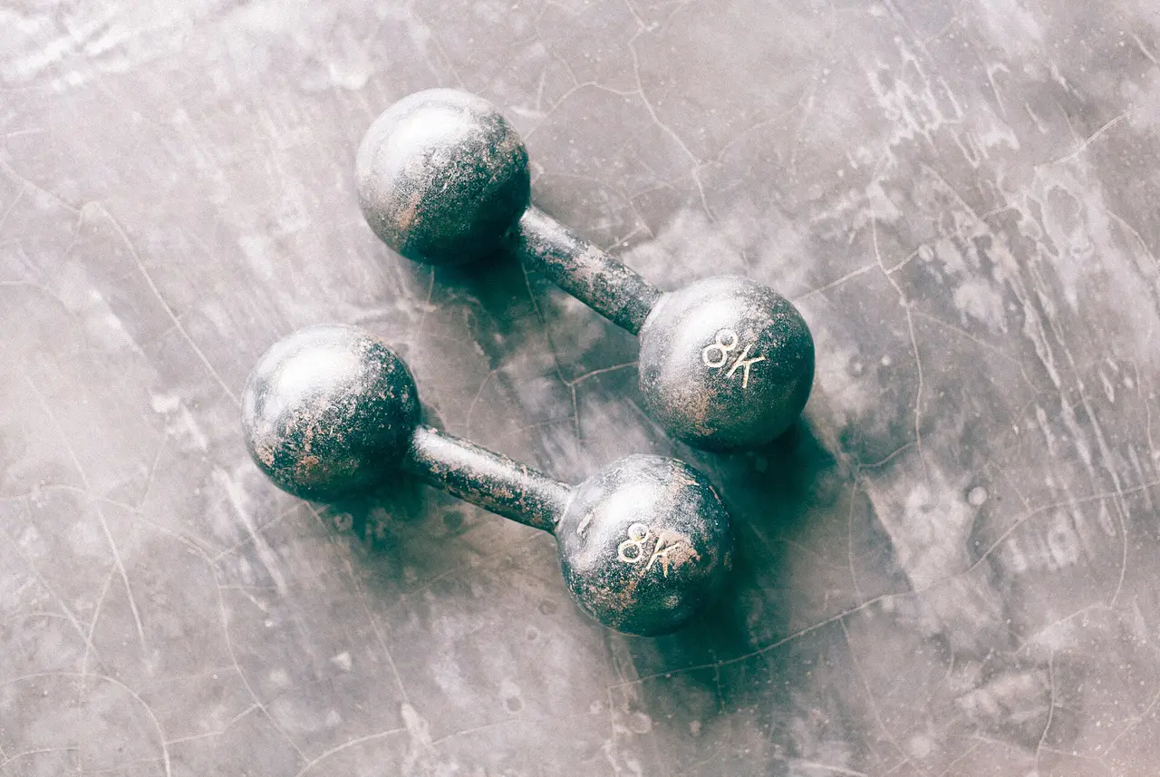 Two dumbbells lying on a grey floor